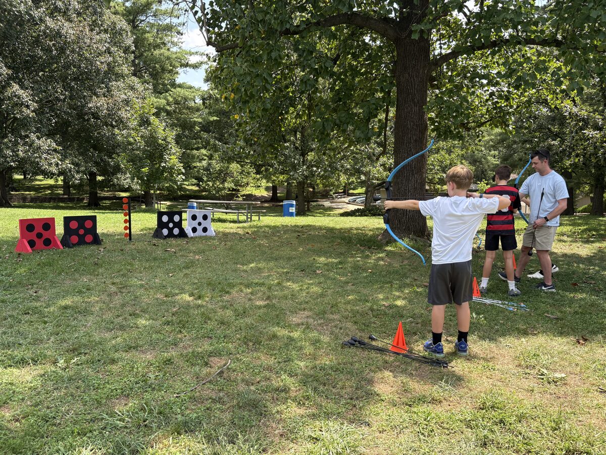 Kids practicing foam-tipped archery with a Rec Academy coach