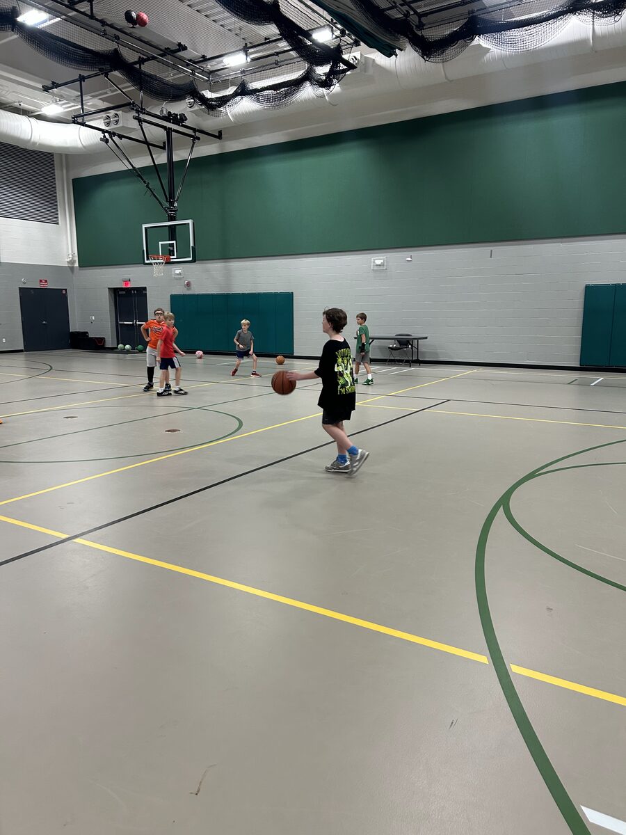 A young player dribbling a basketball during a Rec Academy clinic