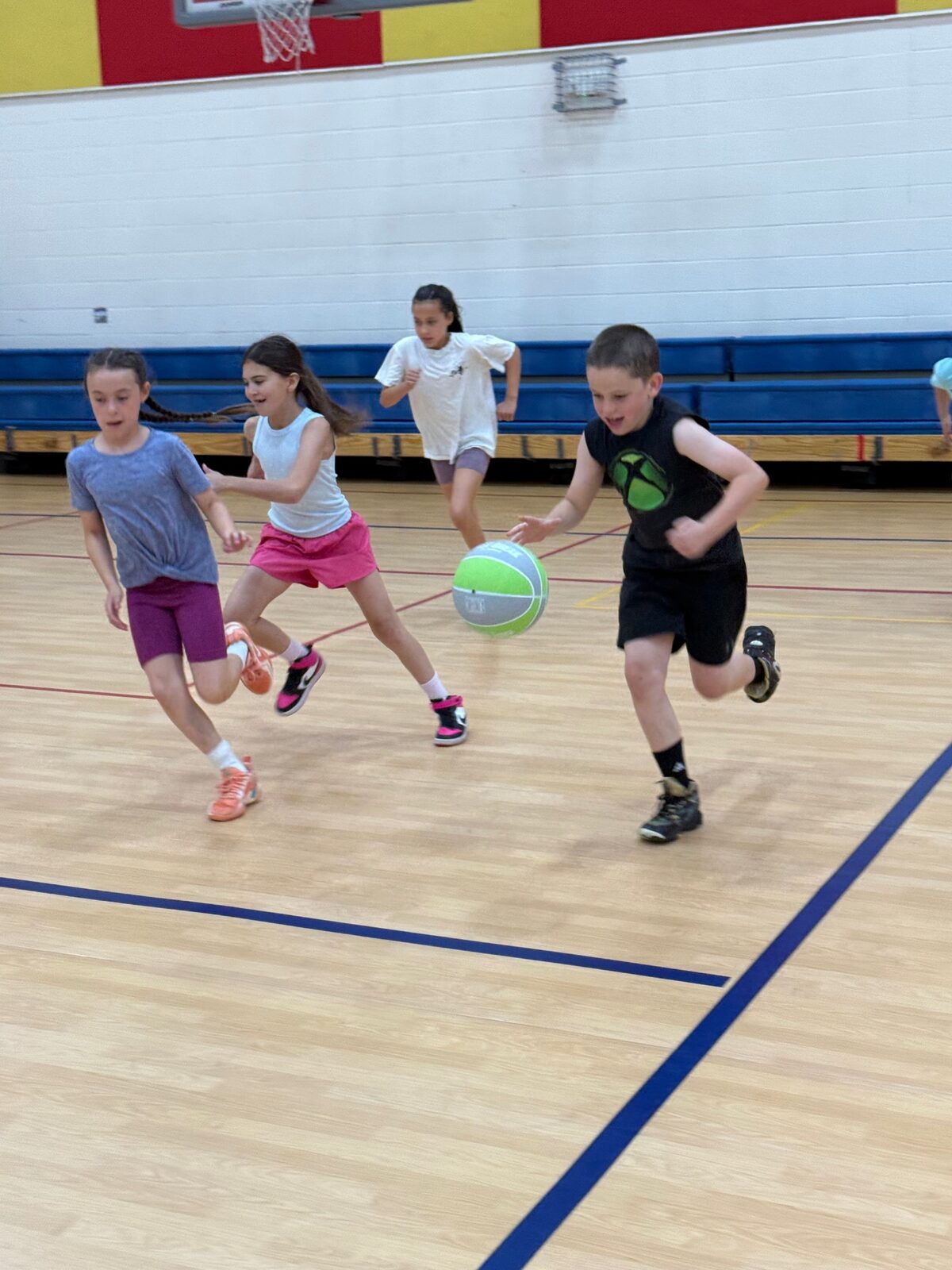 Kids racing down the court in a Recreation Academy basketball game