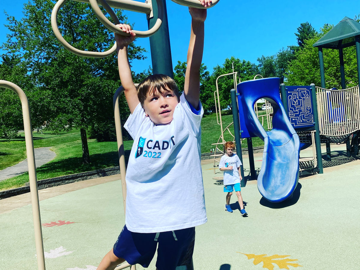 A Recreation Academy camper crossing the monkey bars